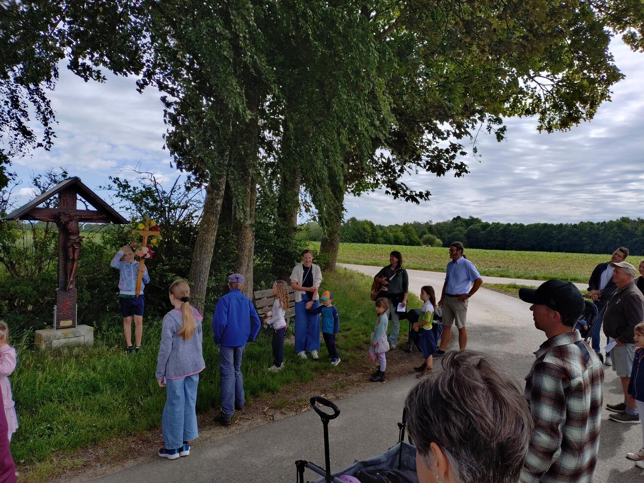 Die Teilnehmer machen Halt bei der 1. Station - Feldkreuz